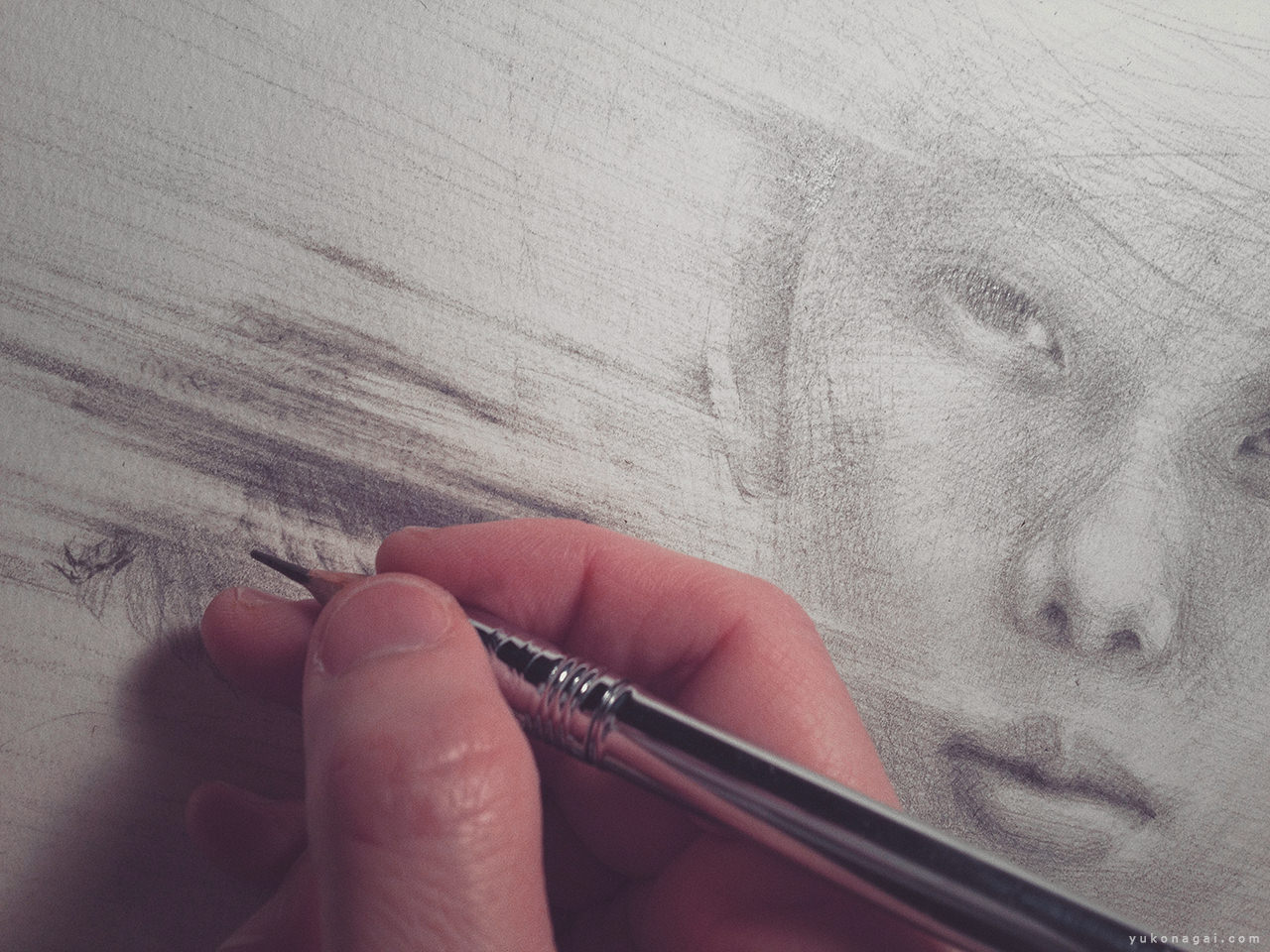 A child portrait in progress and an artist's hand holding a pencil.