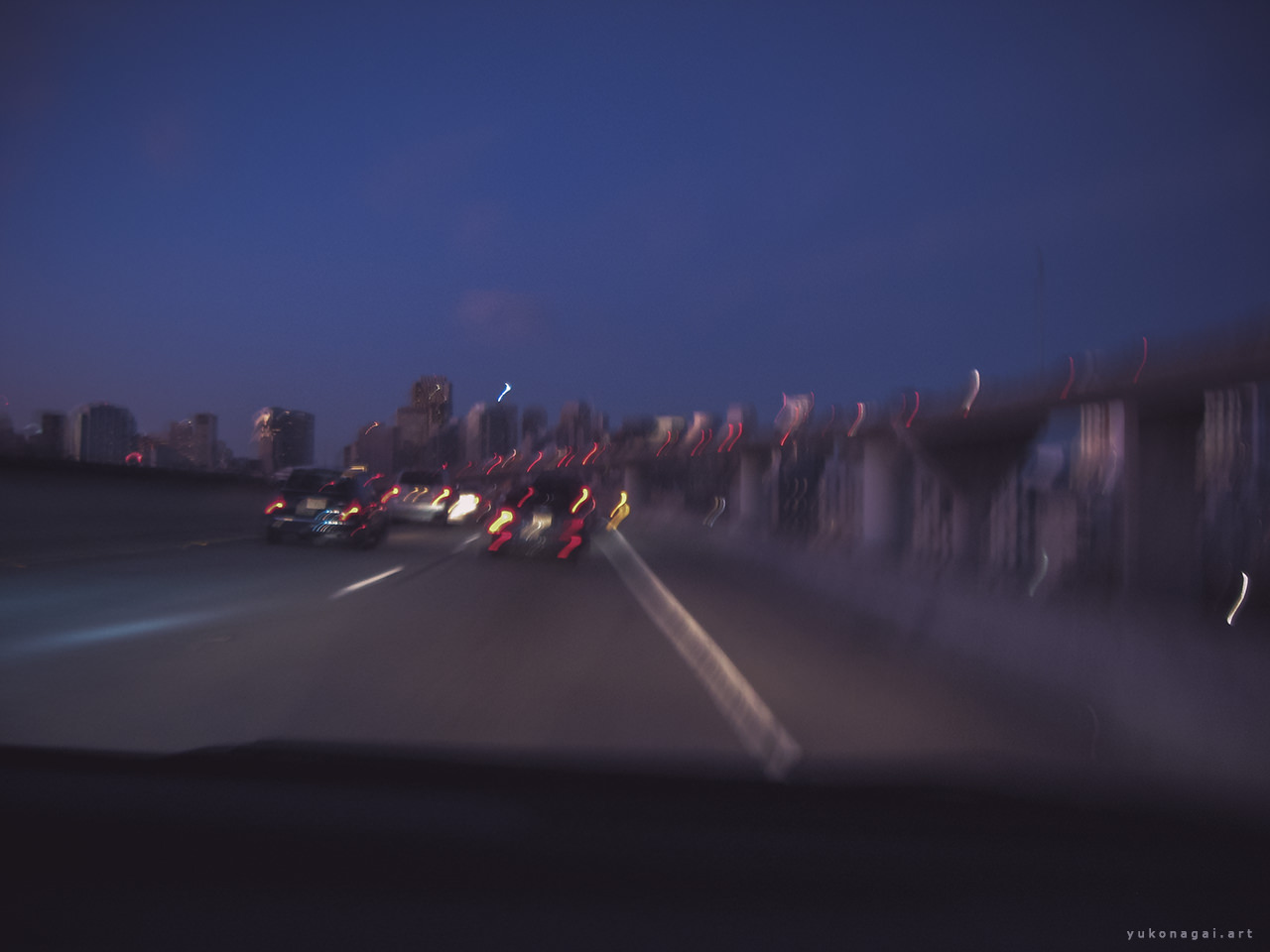 Distant city scape and freeway traffic lights in blur.